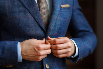Tailoring and Fashion Concept: Hands Buttoning Up a Well-Fitted Suit