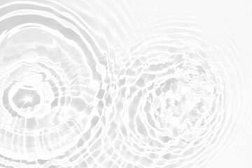 White water with ripples on the surface. Defocus blurred transparent white colored clear calm water surface texture with splashes and bubbles. Water waves with shining pattern texture background.