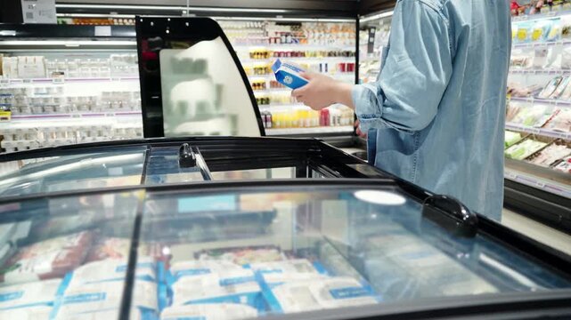 Man Shopping for Frozen Goods in Supermarket Freezer Section
