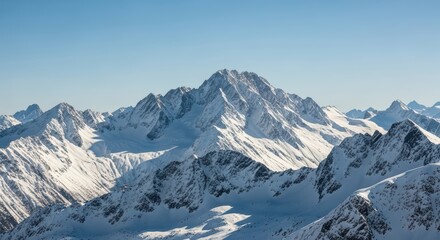 Fototapeta premium Majestic snow-covered mountain peaks under clear blue sky