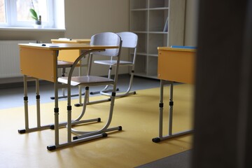 Classroom with yellow desks and chairs at school