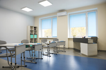 Stylish classroom with desks and chairs at school