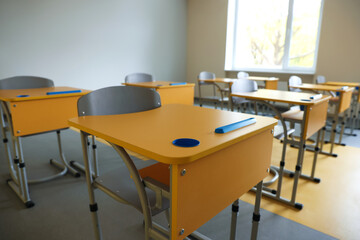 Stylish classroom with desks and chairs at school, closeup
