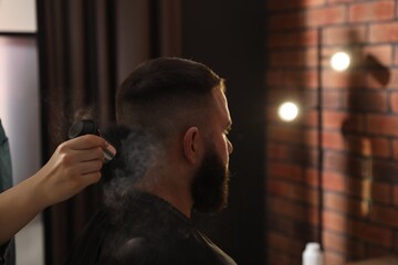 Hairstylist applying talcum powder with brush onto man's neck at salon, closeup. Space for text