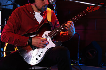 Obraz premium Man playing electric guitar on stage, closeup