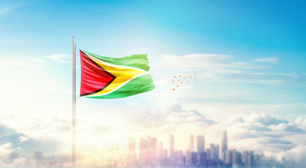 Guyana flag wavering in beautiful clouds with building skyline. The flag with drone shot in beautiful sky. Guyana national flag for independence day.
