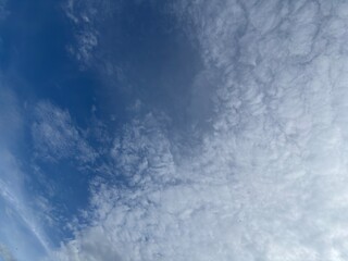 Blue sky filled with soft white clouds, creating a bright and natural atmospheric background.