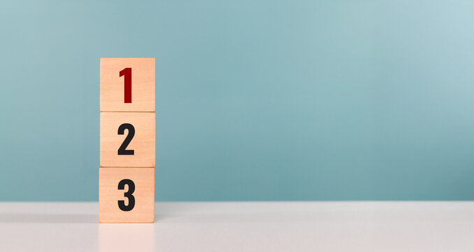 Priority of activities. A man hand place wooden cubes with number one, two and three. Concept of task priority and management