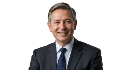 Portrait of a smiling man in a suit and tie against a black background with graying hair neatly styled