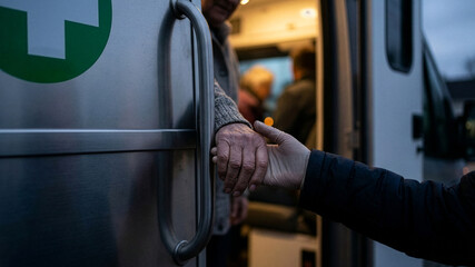 Younger Hand Helping Elderly Person Out of Mobile Healthcare Van – Emotional Care Concept