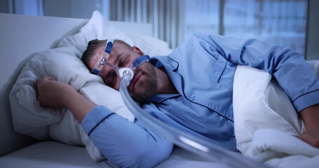 Man Using CPAP Machine Mask