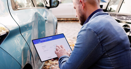 Man Inspects Car Accident Damage, Assesses Cost With Tablet