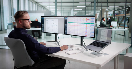 Young Male Coder Using Spreadsheet To Monitor Medical Billing Data