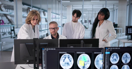 Medical Team Analyzes Brain Scans On Computer Screens Together