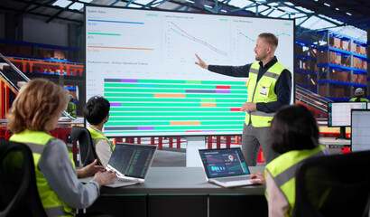 Warehouse Workers Meet With Manager, Analyze Data On Laptop Screen