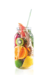 A large clear glass bottle filled with fresh raw fruit and a straw. 