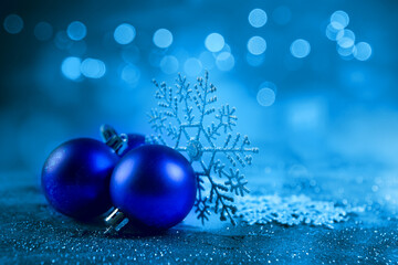 Blue christmas balls and snowflakes on bokeh background