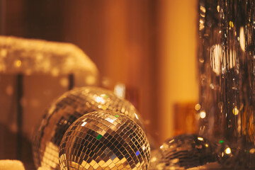 Disco balls reflect light in a festive setting filled with shiny decorations and a warm ambiance during a lively evening party