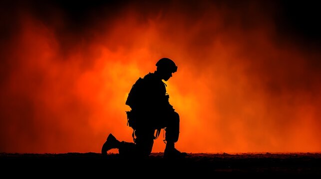 Silhouetted soldier kneels against an intense backdrop of vibrant orange and red flames