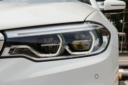 Up-close white automobile headlight showcases sleek design and advanced tech.