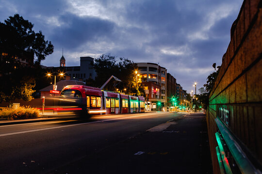 Long exposure red light rail train waiting at Newcastle Beach stop tram station at night 