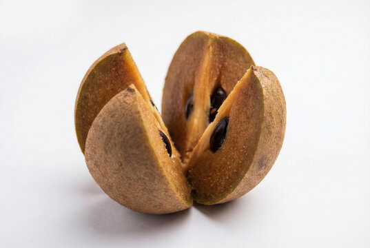 Cut Sapodilla or Naseberry Fruit Showing Seeds Isolated on White Background
