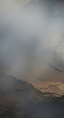 Misty canyon rock formation shrouded in soft atmospheric haze