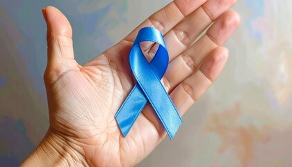 Hand Holding Blue Awareness Ribbon on Gray Background