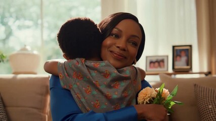 African american son giving mother's day card to mom