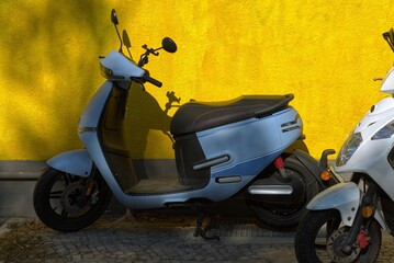 E-scooter on a yellow wall in Berlin.