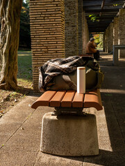 公園のベンチに置いてある荷物と水筒