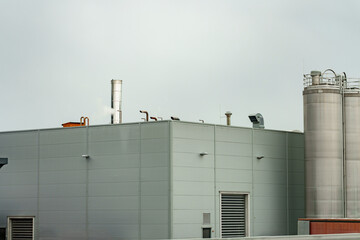 Geometry of industry under a muted sky, a gray industrial building scene with silver silos