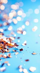Scattered golden confetti and blurred bokeh lights create a festive and celebratory atmosphere on a vibrant blue surface.