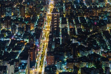 Aerial view of a vibrant city street at night illuminated by lights