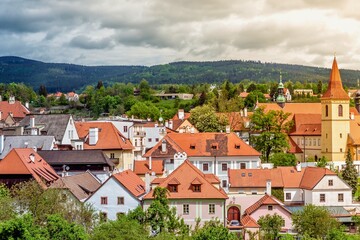 Charming european town with red tiled roofs and green hills