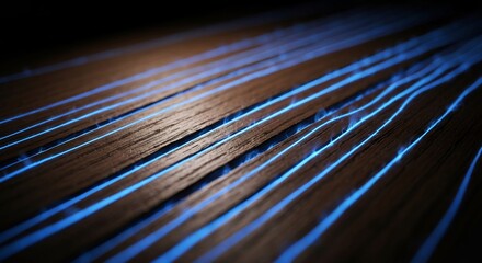 Angled view of dark brown textured wooden surface with parallel bright blue glowing lines in its grooves
