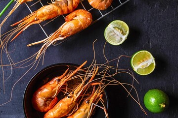 Delicious grilled prawns with fresh lime on a dark background