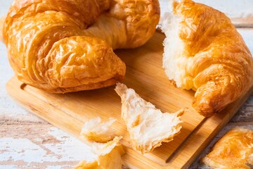 Golden croissants on a wooden board ready to eat