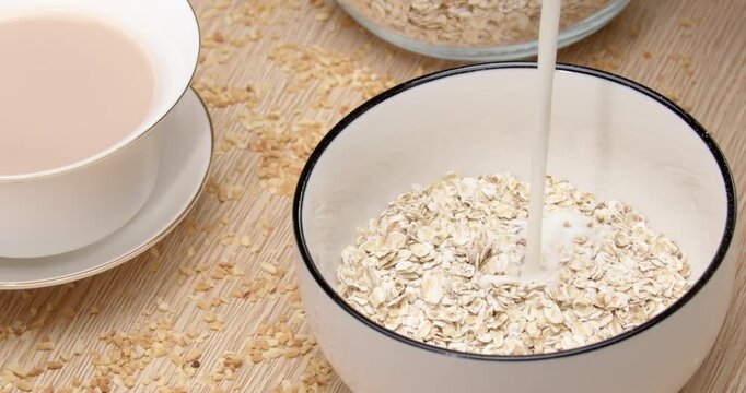 Bowl of Dry Oats Ready for Milk Pour Over to Make Healthy Breakfast Oatmeal on Wooden Table