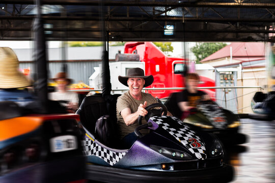 Bumper cars ride with Aussie man riding dodgem car at carnival show ride smiling