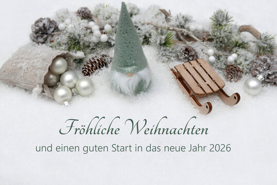 Weihnachtskarte: Weihnachtsgr&uuml;&szlig;e mit Wichtel, Schlitten und Weihnachtsschmuck im Schnee . Fr&ouml;hliche Weihnachten und einen guten Start in das neue Jahr 2026.