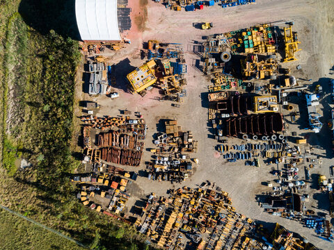 Overhead aerial of industrial parts stockyard with pieces of machinery laid out on ground