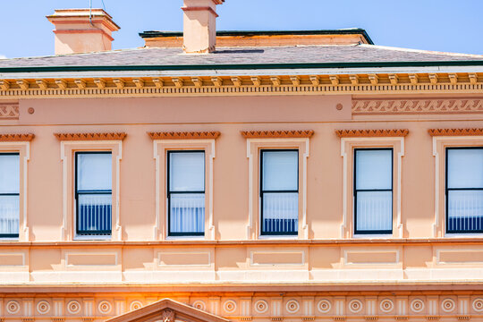 second story windows in creamy pink historic building in country town of Glen Innes