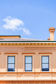 second story windows in creamy pink historic building in country town of Glen Innes