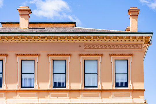 second story windows in creamy pink historic building in country town of Glen Innes