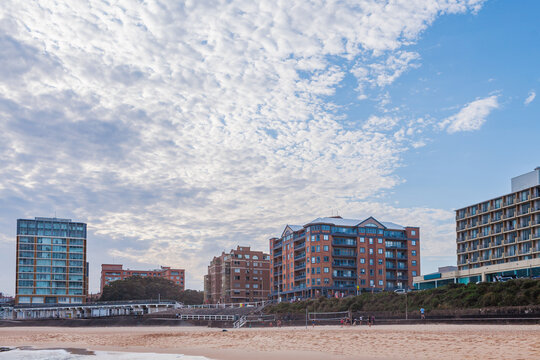 Coastal city landscape of apartment buildings seen across sand and beach volleyball game