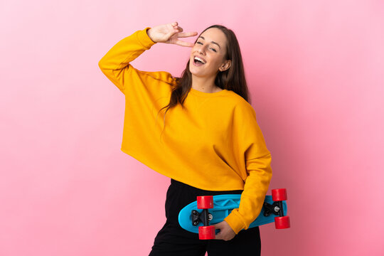 Young hispanic woman over isolated pink background with a skate with happy expression - Powered by Adobe
