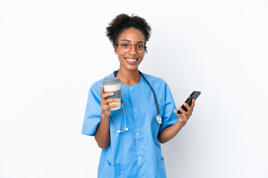 Young surgeon African American doctor woman isolated on white background holding coffee to take away and a mobile