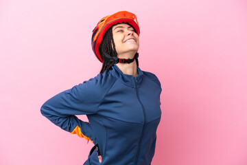 Teenager cyclist girl isolated on pink background suffering from backache for having made an effort