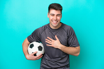 Young caucasian football player man isolated on blue background smiling a lot